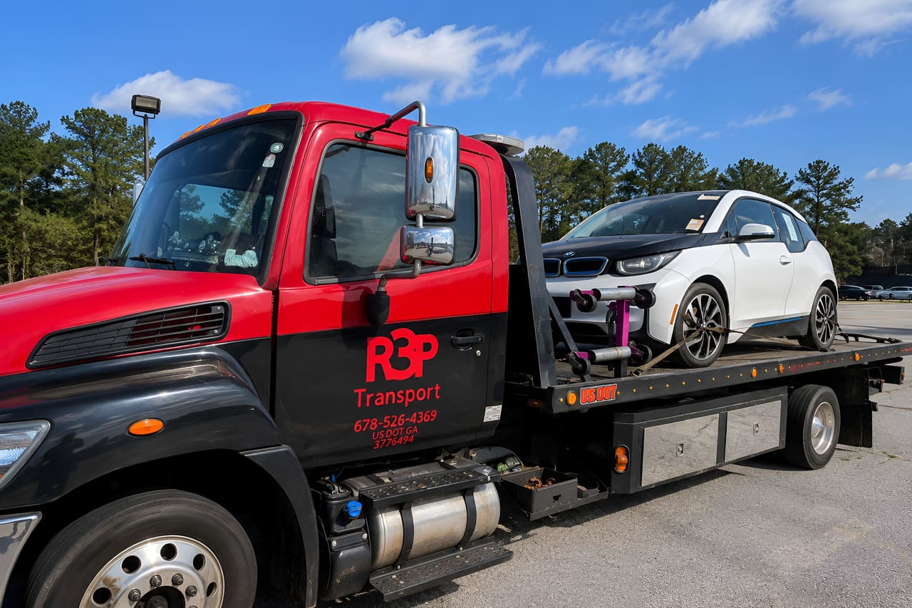 R3P Transport rollback carrying a white electric car